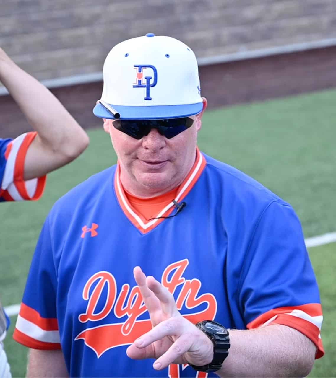 man in baseball uniform putting up two fingers